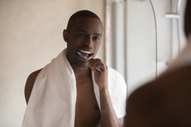 istock African American man brush teeth looking in mirror 1201492857