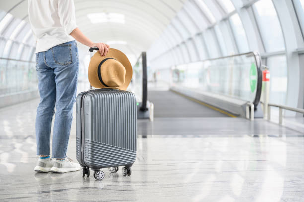 verano y concepto, una mujer con maleta caminando en el aeropuerto - equipaje de mano fotografías e imágenes de stock