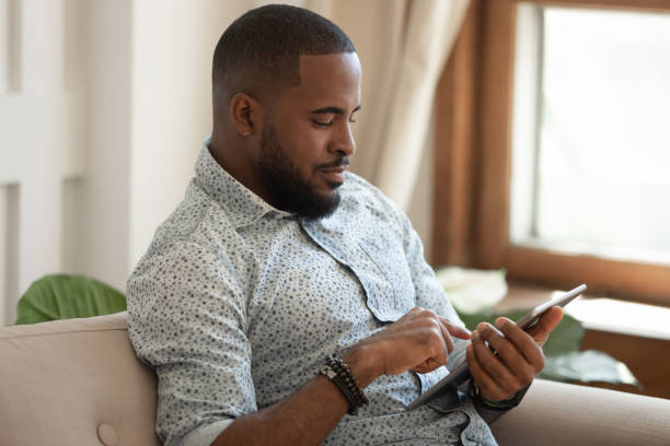 istock African American man rest at home using tablet 1201494907