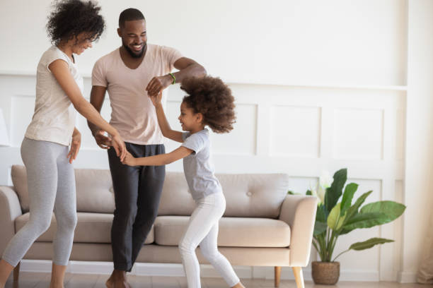 felice famiglia birazziale con bambini che ballano a casa - african descent american culture exercising women foto e immagini stock