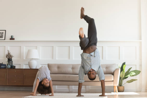 Active biracial dad and daughter exercise at home