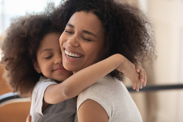 istock Cute biracial daughter hug smiling young mom 1201494985