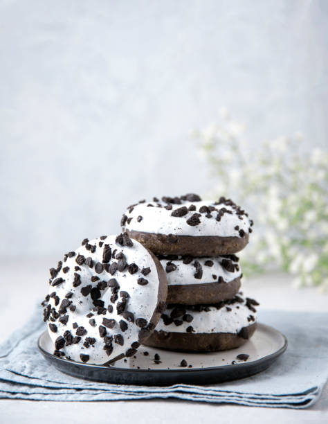 istock several delicious fresh hearty black and white doughnuts are stacked in a white plate on a white background 1201497150