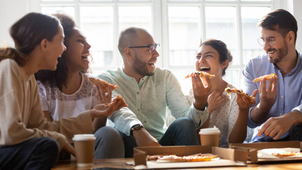 istock Overjoyed multiethnic millennial friends eating pizza at home 1201499375