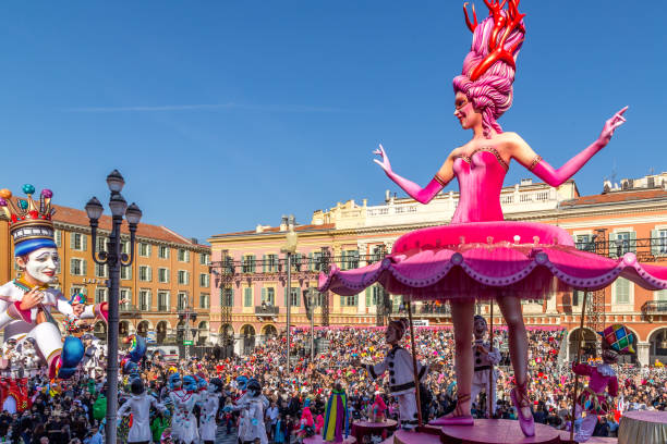 Carnaval de Nice, This years theme King of Cinema (ROI du Cinéma) - Nice, Cote d’Azur, France - February 24 2019: Carnaval de Nice, This years theme King of Cinema (ROI du Cinéma) - Dancing ballerina float looks back at the King of Carnaval with hundreds of people in the audience nice carnival france stock pictures, royalty-free photos & images