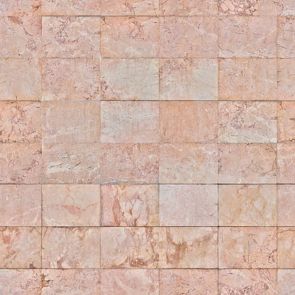 Pink granite tiles for the interior of the house with textured scratches on the surface
