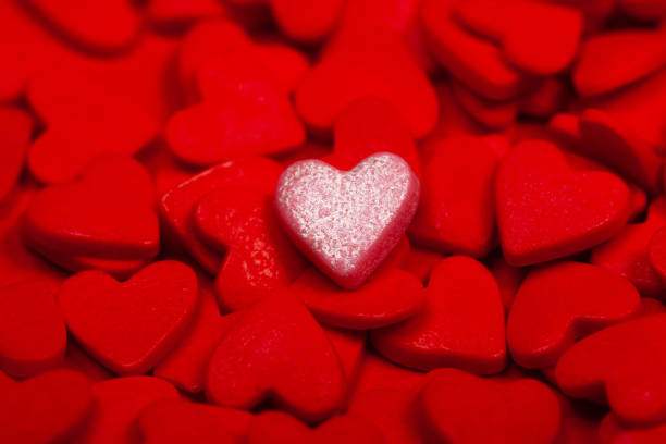 istock A lonely heart among many red hearts 1201503810