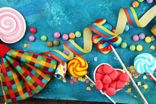 istock Colorful carnival border over a cool textured background with copy space with party hats, candy, streamers and hearts. Party Carnival decoration 1201505439