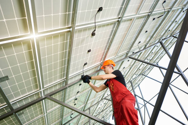 istock Solar power station with large volumes. Young man inside her is setting up a system. 1201507177