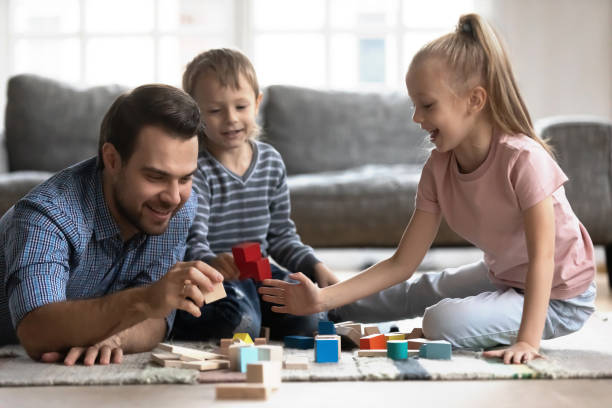 istock Young dad playing with kids building with bricks 1201510267
