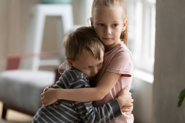 piccolo figlio fratello e sorella abbraccio mostrando amore - fratello foto e immagini stock