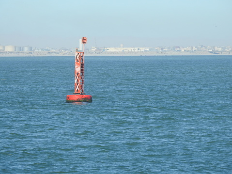 Seascape of buoy sways and floating in the sea  as safety warning and navigation marker at harbor or port on a sunny day. seagulls perched on buoy.