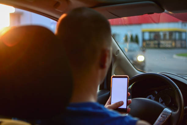 istock Person Sending Text Message By Mobile Phone While Driving Car 1201510509