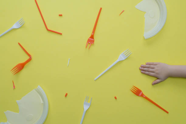 istock Plastic garbage and children's hand on yellow. 1201510634