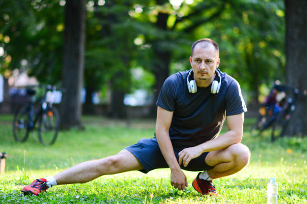 istock Man doing stretching exercise, Stretching, Sports Training, Public Park, Athlete 1201510726