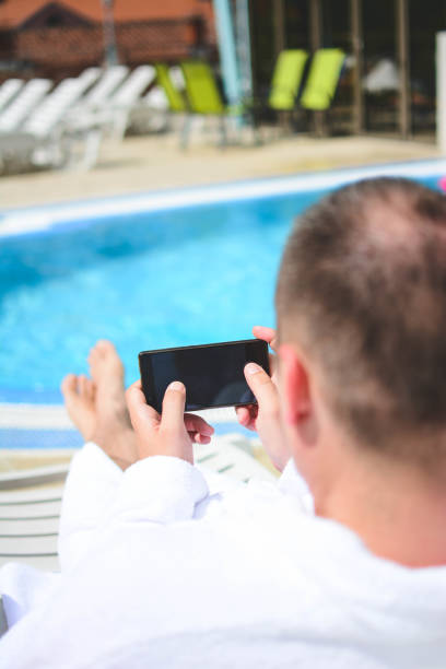 istock Businessman talking on mobile phone looking at spa center. Rear view. 1201510839