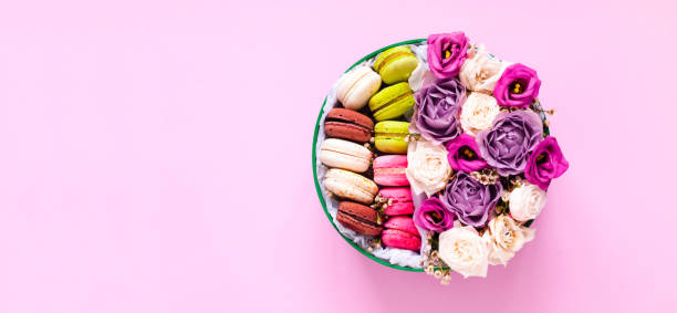 istock Festive concept from rosebuds in full bloom and Multicolored Macaroons on pink background. Valentines Day. Template mock up of greeting card or text design. Close-up 1201512040
