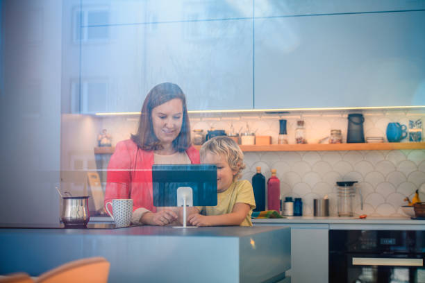 istock Mid Adult Mother and Young Son Indoors Using Digital Tablet 1201512092