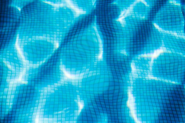 Swimming pool, mosaic bottom. Flow with waves, sport and relax concept. Summer background. Texture of water surface. Top view.