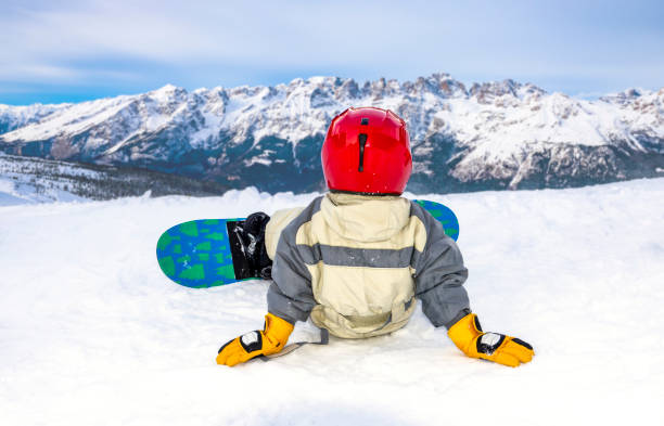 istock Child on the slopes for the first time on a snowboard 1201513277