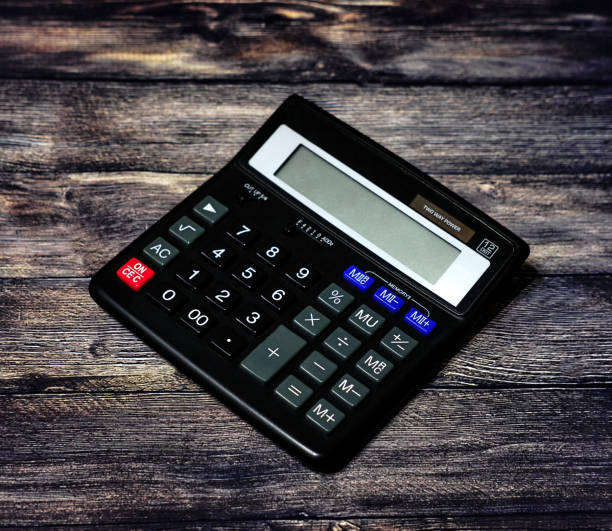 istock Black calculator to count numbers on a wooden background 1201515727