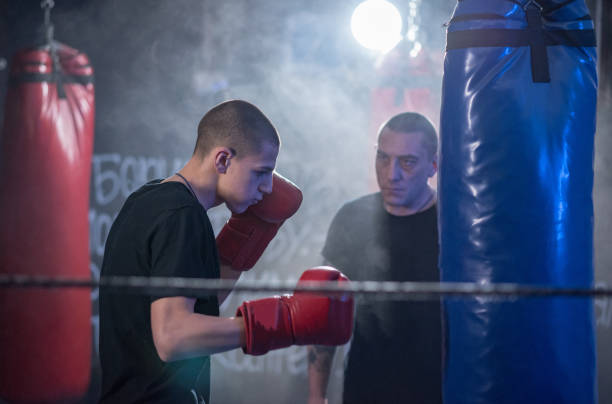 istock kickboxer exercises blows on the pear in the gym 1201517124