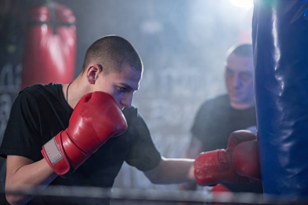 istock kickboxer exercises blows on the pear in the gym 1201517134