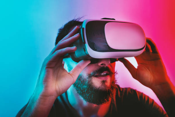 istock Man with Virtual Reality Glasses on a blue and red colored background. 1201518639
