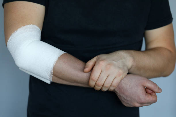 istock Male hand with tight elastic bandage on elbow closeup 1201521003