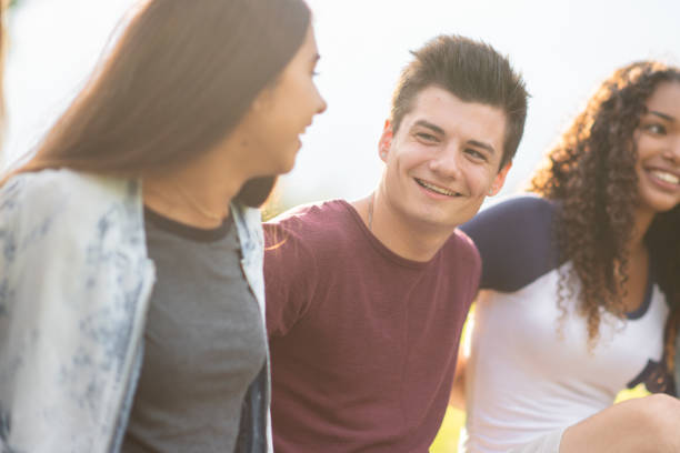 istock Three Post Secondary Students Outside Locking Arms stock photo 1201521376