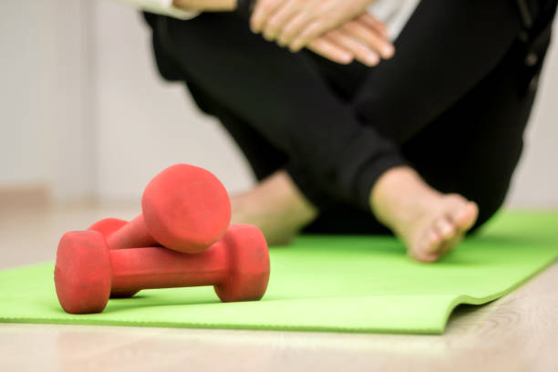 istock Hand weights with a man in the background. 1201522085