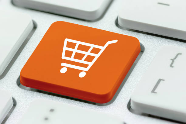 オンラインショッピング/eコマースと小売販売の概念:チェックアウトのためのホワイトバスケット、ラップトップキーボード上のショッピングカートのシンボルは、顧客がインターネットを� - catalog internet e commerce customer ストックフォトと画像
