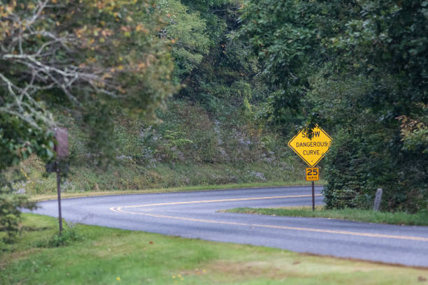 istock Yellow Dangerous Curve Sign Along a Mountain Roadway 1201527614