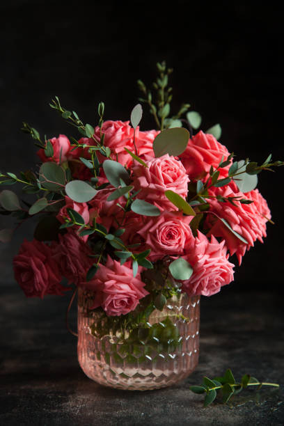 istock Pink roses in a vase on a dark background. 1201530566