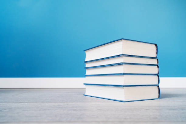 istock Pile stack of books on the floor or table in front of the blue wall 1201531484