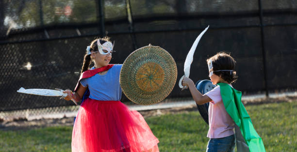 istock Hispanic children in superhero costumes, rivalry 1201536893
