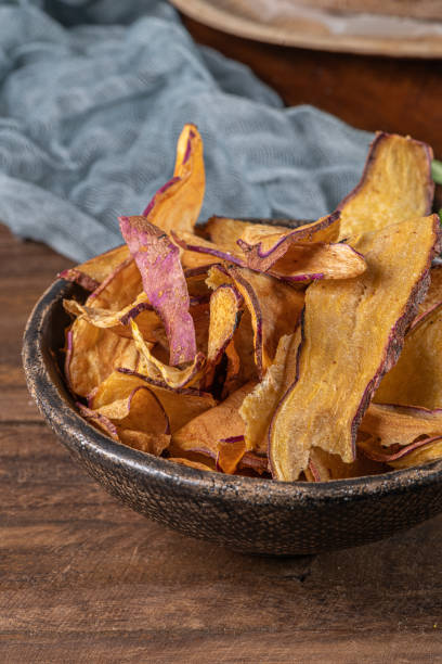 istock Delicious sweet potato chips in bowl, on table. 1201538625