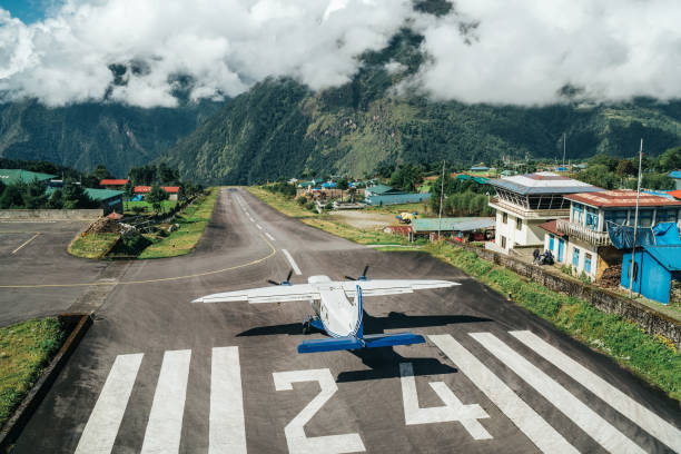 aereo bimotore a corto raggio che atterra sulla pista dell'aeroporto più pericoloso del mondo a lukla, in nepal. aeroporto di tenzingâhillary a quota 2.845 m - runway airport airfield asphalt foto e immagini stock