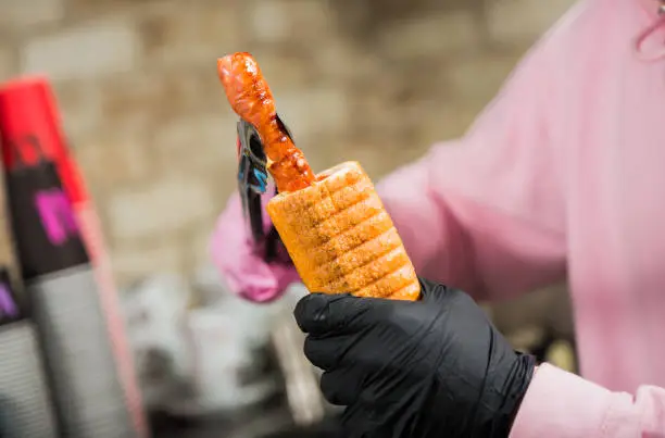 Photo of bartender putting grill sausage in roll