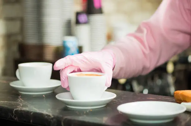 Photo of bartender putting fresh coffee on counter