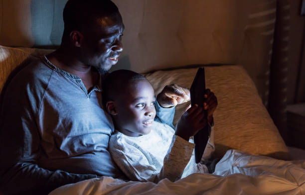 istock Father reading bedtime story to son, on digital tablet 1201540843