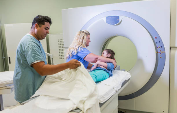 istock Technologist talking to girl getting CT scan 1201542056