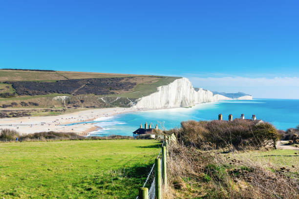 Cuckmere Haven, Seaford, England Walk to Cuckmere Haven beach near Seaford, East Sussex, England. South Downs National park. View of blue sea, cliffs, selective focus east sussex stock pictures, royalty-free photos & images