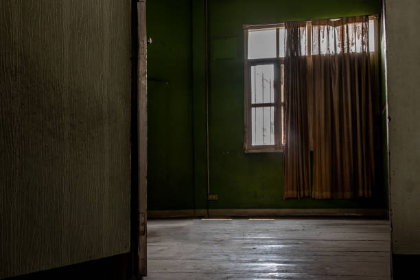 istock Abandoned room with big window was left to deteriorate over time, Abandoned house, Destroyed house, Ruined house. 1201545368