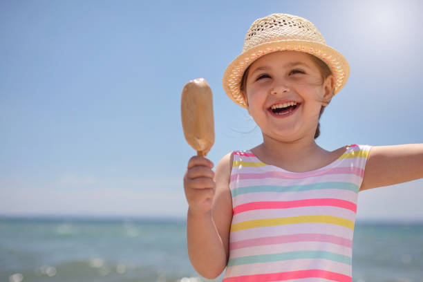 istock Cute child with an ice cream smiling on the beach 1201546316