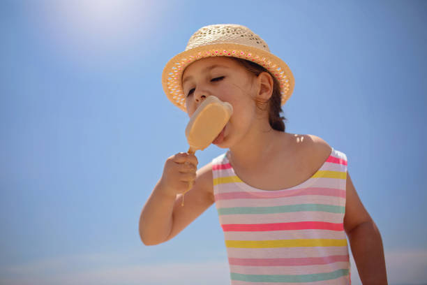 istock Cute child eating an ice cream on a sunny day 1201547119
