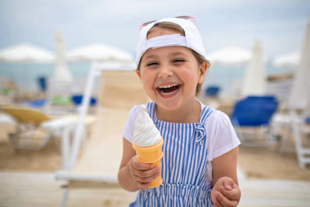 istock Cheerful ecstatic child with an ice cream cone on a beach 1201547163