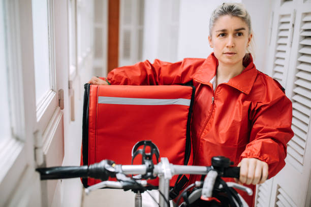 istock Food delivery woman getting ready for work 1201555216