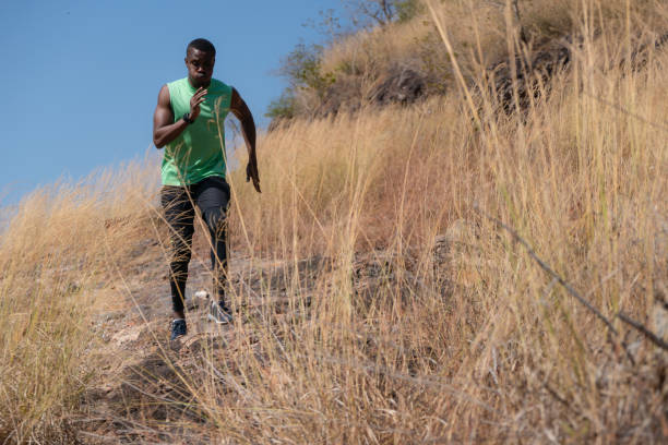 istock african american trail runner running on trail in natural mountain 1201558219