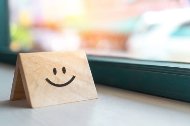 Smiley face icon on wood sign board. Optimistic person or people feeling inside and service rating, satisfaction concept in business.